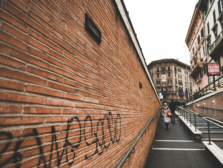 woman walking on alley beside stairway, person walking near rail and wall during daytime HD wallpaper
