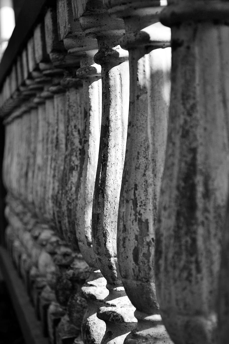 grayscale photography of concrete baluster, grills, sculpture