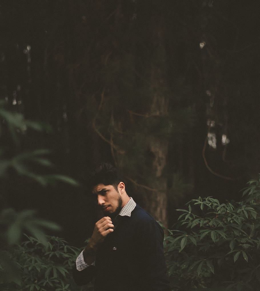 selective photography of man in black top, man standing near tree trunk HD wallpaper