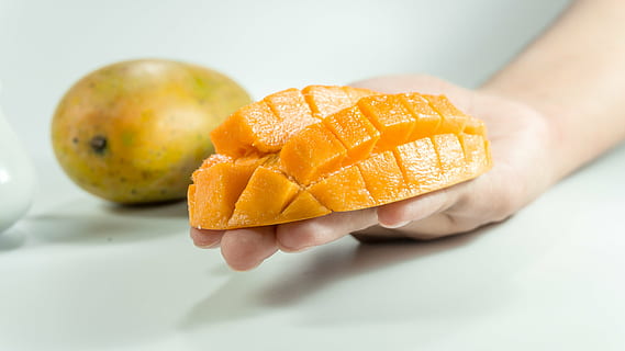 slice mango on person's hand, on hand, yellow, isolated, cube HD wallpaper