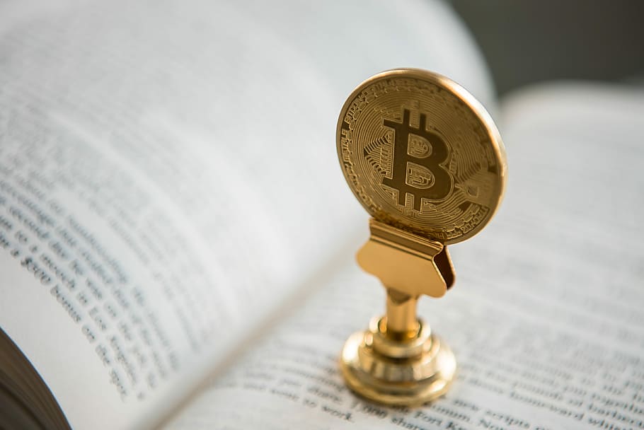 bitcoin on gold stand on top of book, gold-colored Bitcoin on book HD wallpaper