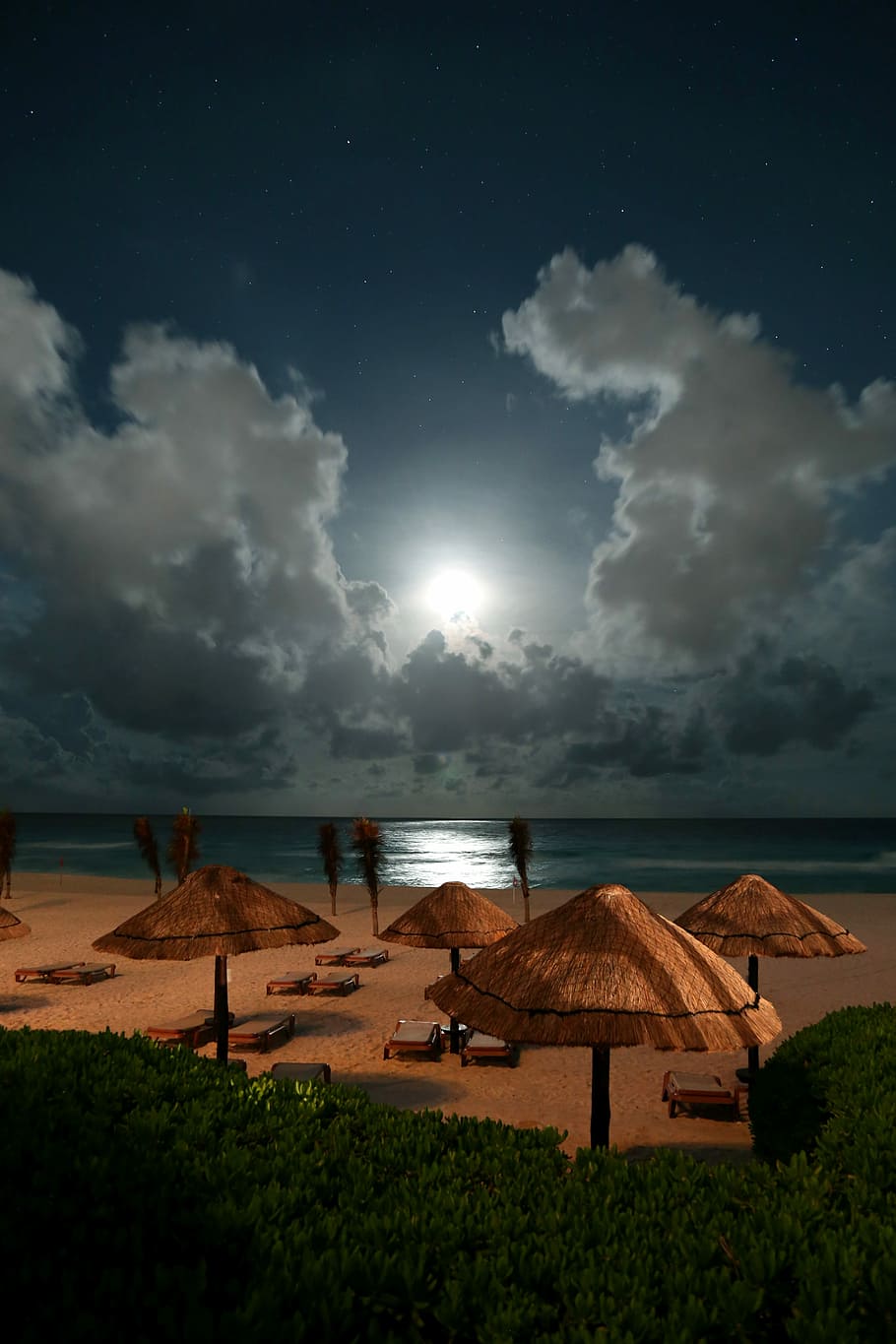 patio umbrella near body of water, four brown beach umbrellas near blue body of water under nimbus clouds at daytime HD wallpaper