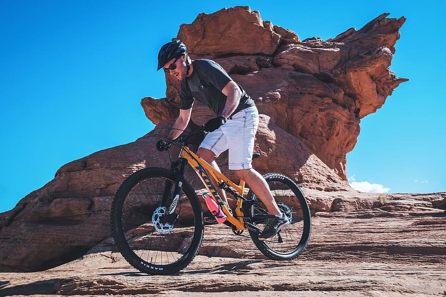 A man riding exercises on a mountain bicycle on rocky terrain