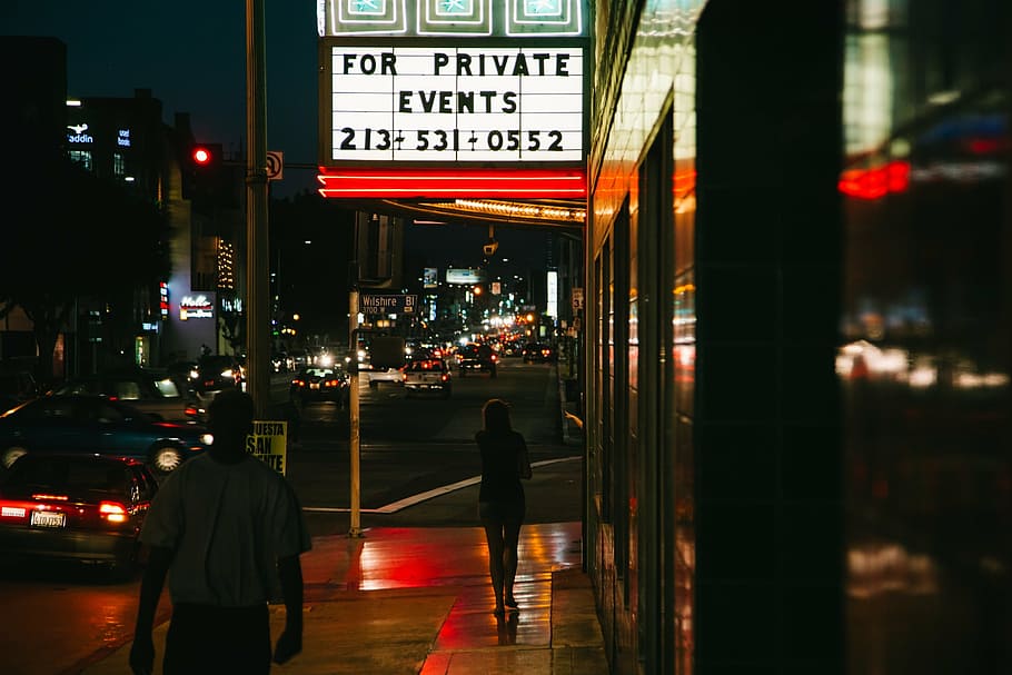 photo of person standing near signage during nighttime, street