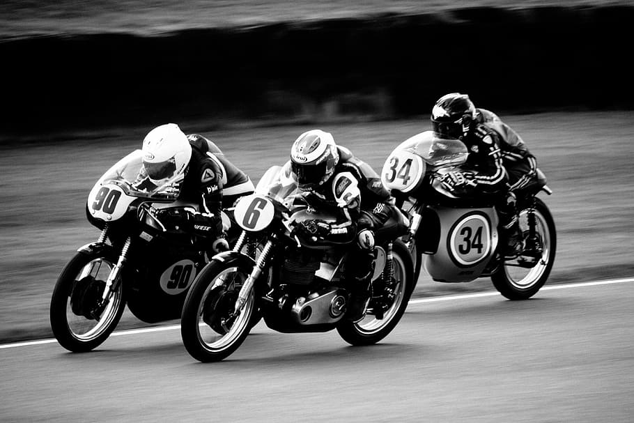 grey scale photo of motorcycle racing in action, person driving sports bike