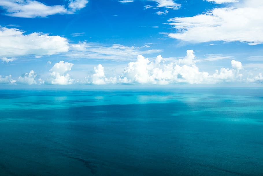 blue ocean under blue cloudy skies, landscape photography of horizon