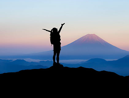 silhouette of woman raising her hands on top of mountain during daytime HD wallpaper