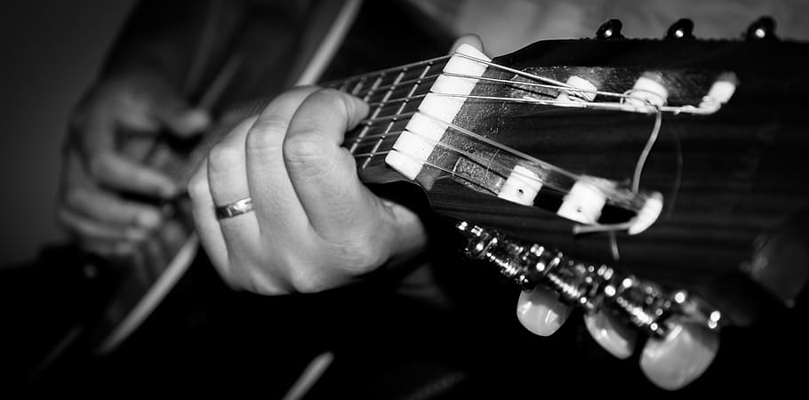 human performing acoustic guitar grayscale photo, playing guitar