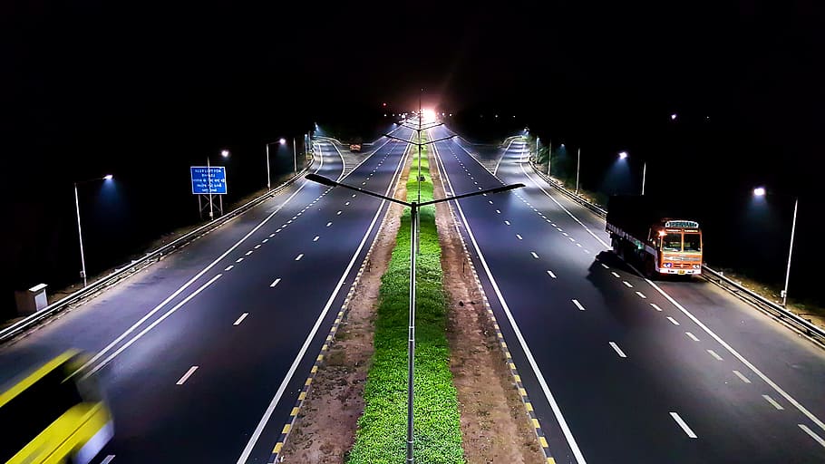 vehicles traveling on roads at night, orange bus at highway photography during nighttime