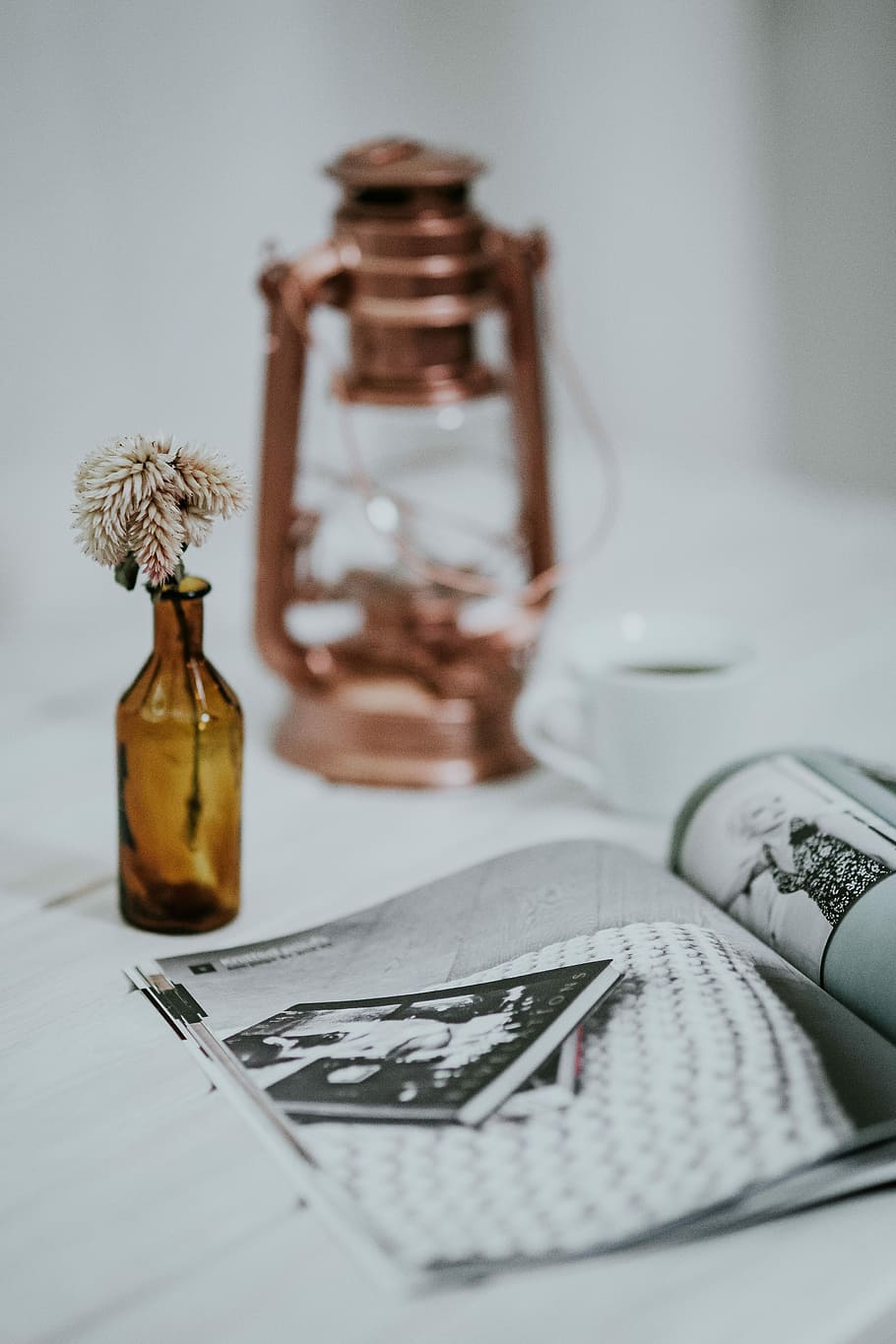 Magazine with a paraffin lamp on a white table, bottle, journal HD wallpaper