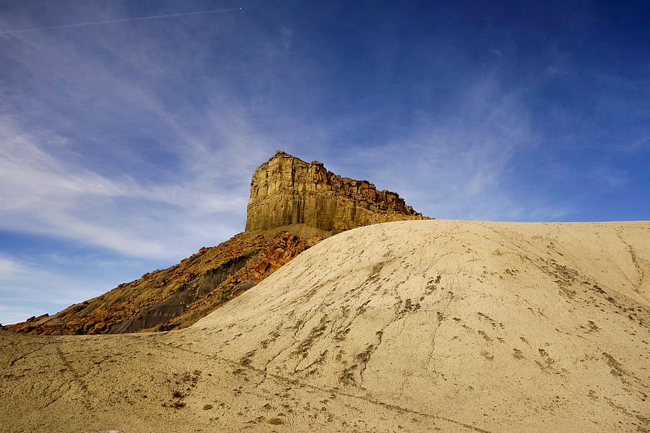 landscape photography of mountain, rock mountain over gray sand HD wallpaper
