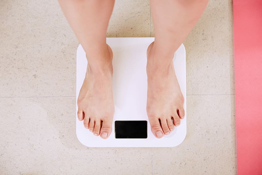 Bare feet standing on a scales. Lose weight concept with person on a scale  measuring kilograms. Weight Scale, Underweight man on Scale Stock Photo -  Alamy