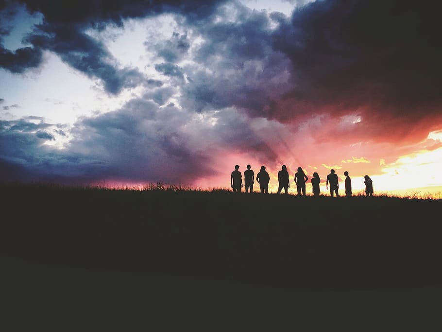 silhouette of people under gray clouds at golden hour, mountain HD wallpaper