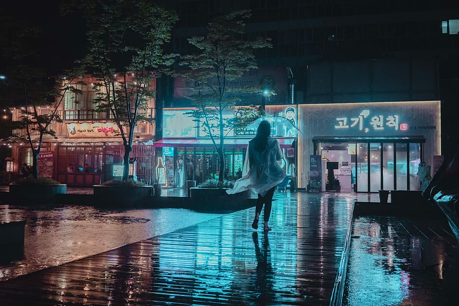 Last night’s storm, woman walking under the rain wearing raincoat