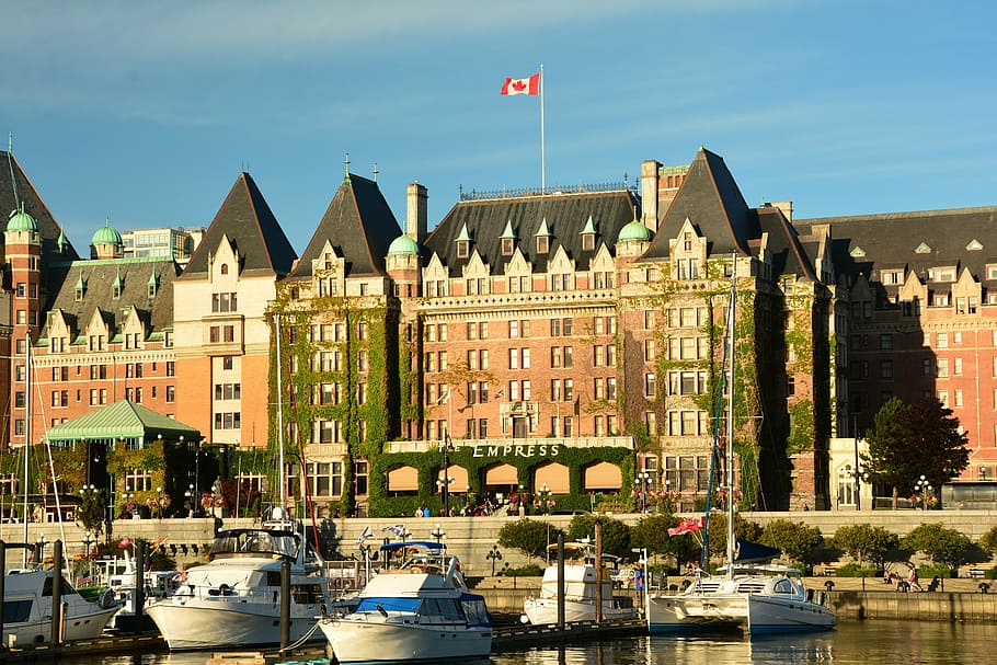 white boats near red building, empress hotel, victoria, inner harbor