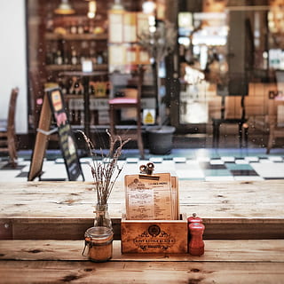 clear glass hermetic jar on top of brown surface, two brown condiments shakers beside menu and air-tight jar on brown wooden table top HD wallpaper