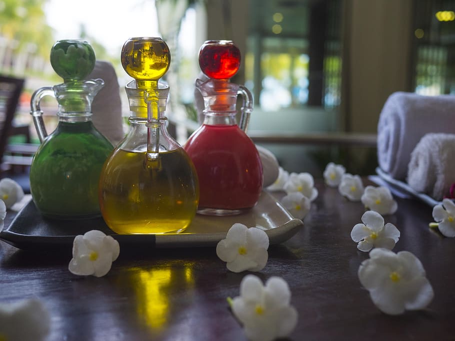 three yellow, red, and green cruets in tray, essential oil, spa