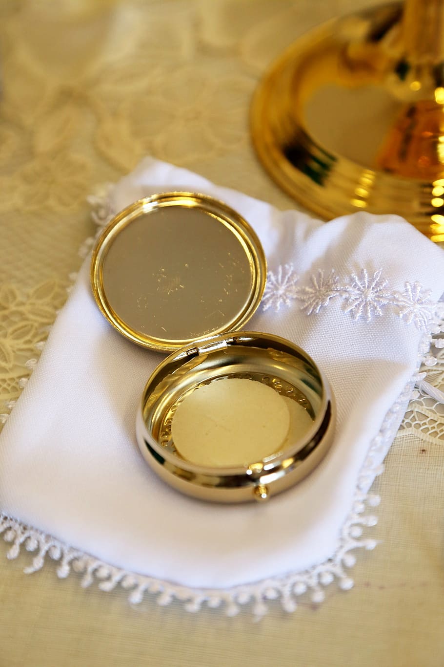 round gold-colored case, eucharist, host, communion, catholic