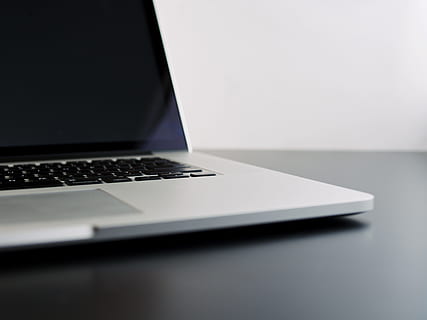 silver laptop computer on black table, MacBook Pro on black surface HD wallpaper
