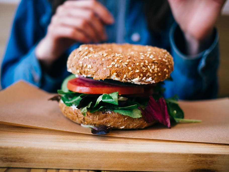 tilt photography of burger on brown pad, tomato, vegetable burger on table HD wallpaper
