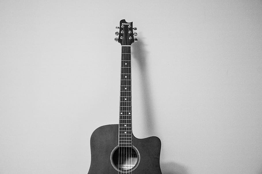 cutaway acoustic guitar near wall, grayscale, photo, music, instrument
