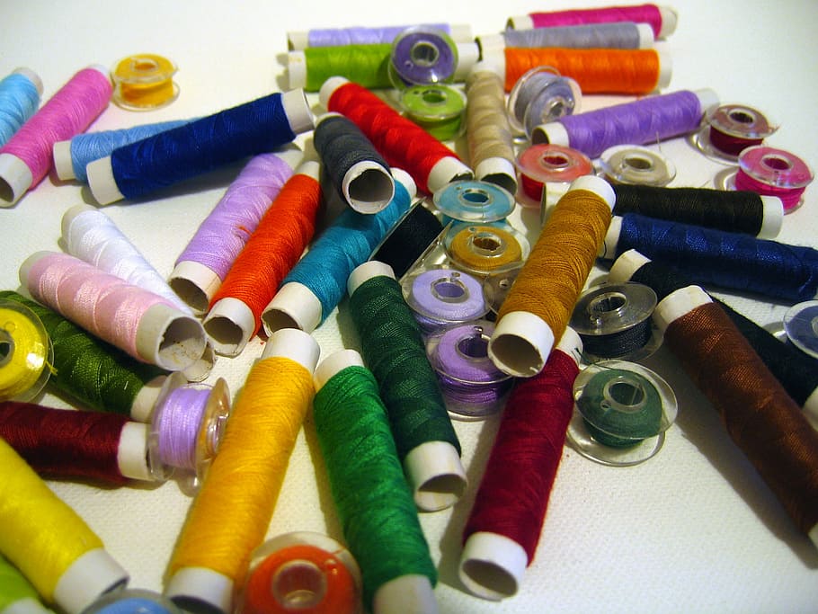 assorted-color thread lot on white surface, Yarn, spools of thread