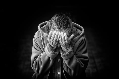 grayscale photo of person in button-up hooded jacket putting his hands in his eyes HD wallpaper
