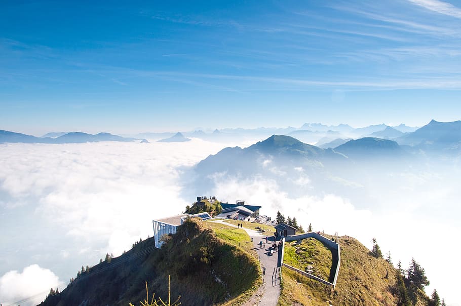 white concrete house near cliff during daytime, people on top of mountain HD wallpaper