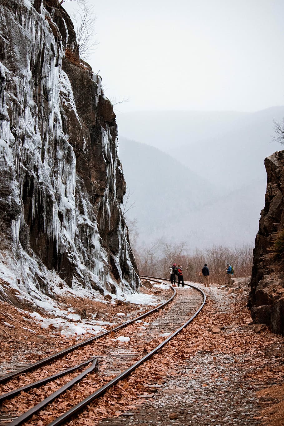four men standing on train railway, person standing on trail rails under cloudy sky HD wallpaper