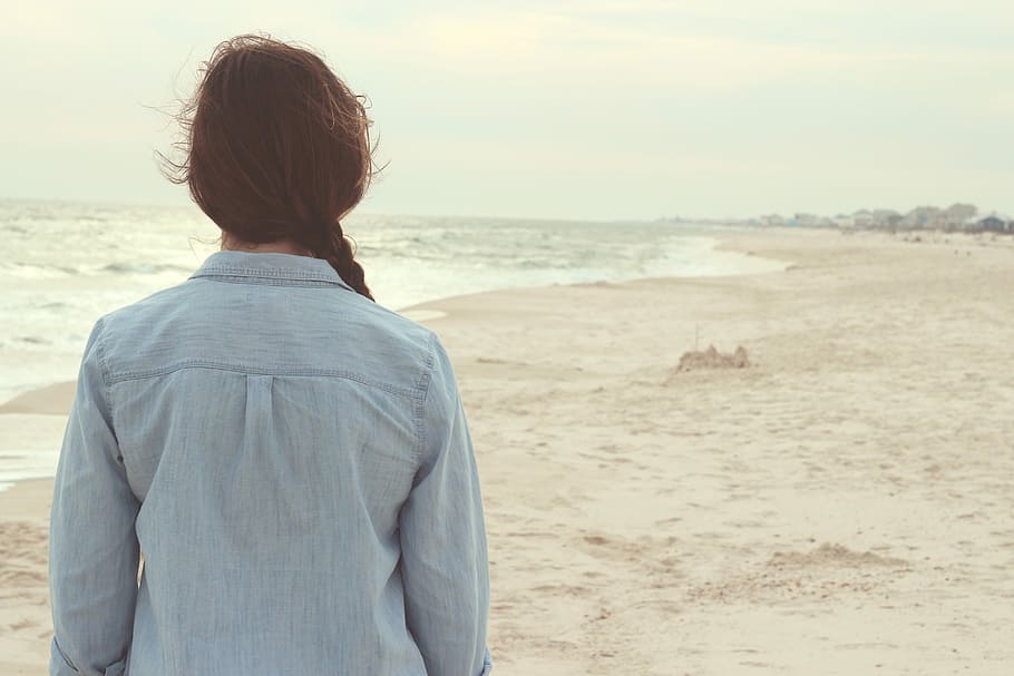 blue denim long-sleeved top near body of water during daytime HD wallpaper