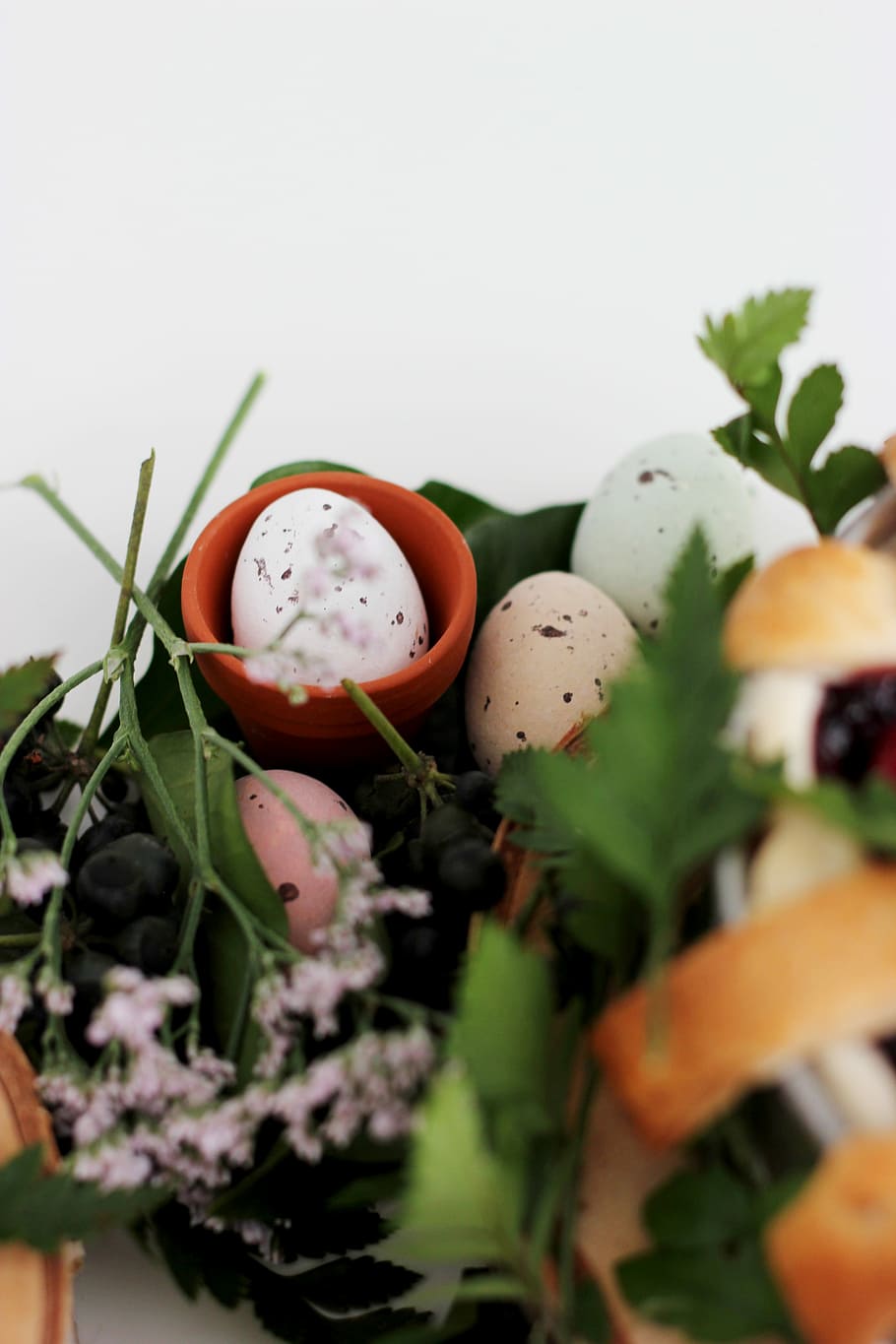 assorted-color organic eggs beside pink petaled flower, white egg on brown clay pot HD wallpaper