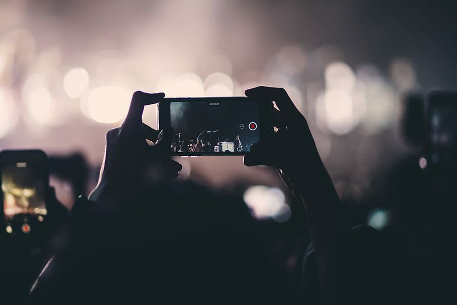 person holding phone videoing, focused photo of a person using black smartphone HD wallpaper