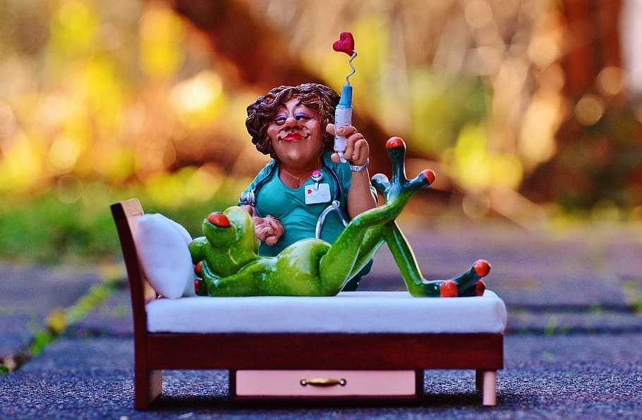woman sitting beside frog lying figurines, nurse, sweet, bed