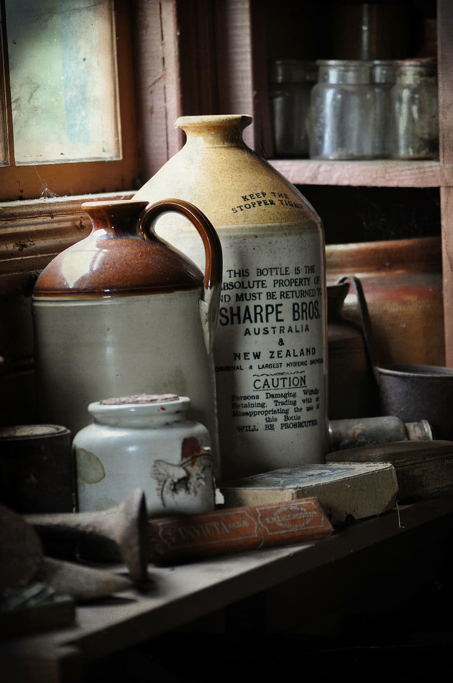 several stoneware jugs on wooden table near rack, old, bottle