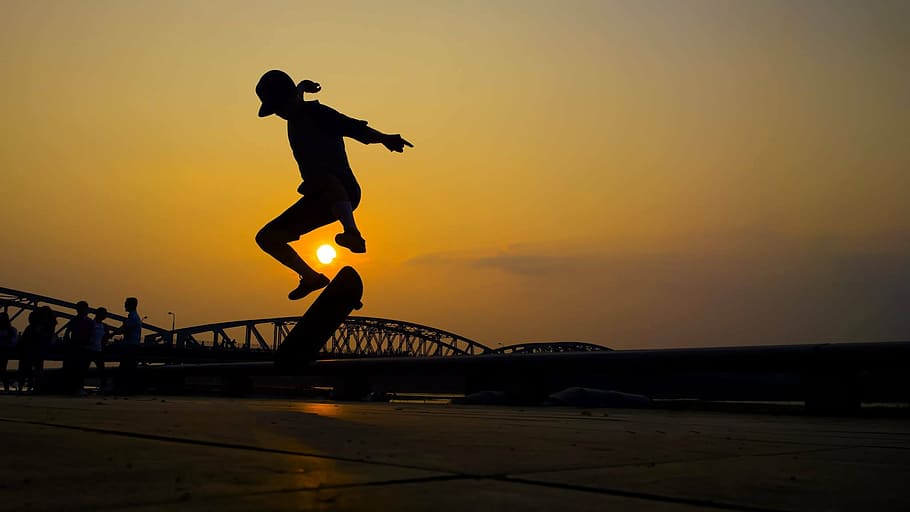 silhouette photo of person skating during golden hour, youth