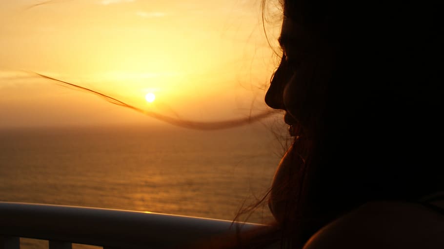 silhouette photography of woman near body of water during golden hour HD wallpaper