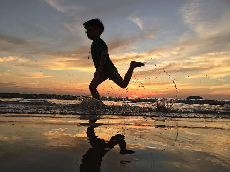 silhouette of boy running on body of water during sunset, kids HD wallpaper
