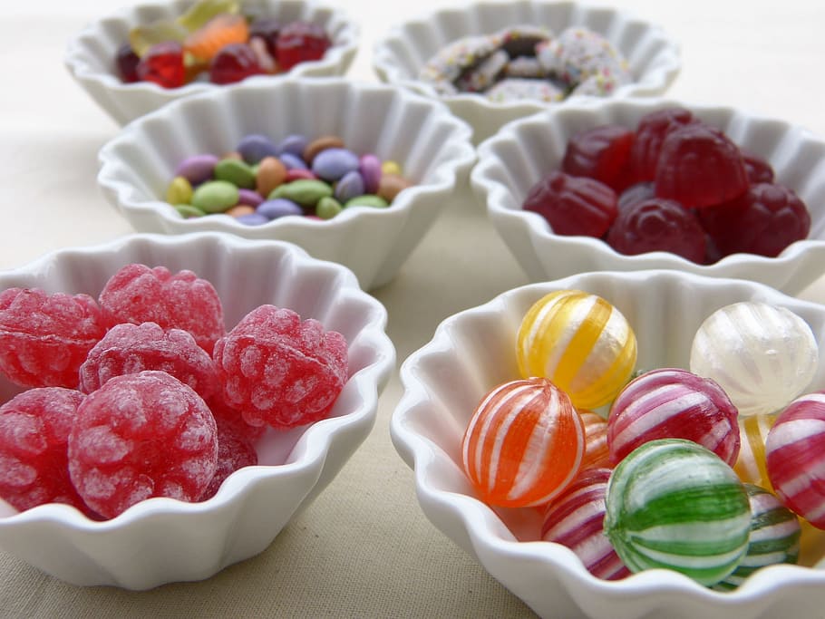 selective photography of assorted candies in ceramic bowls, candy