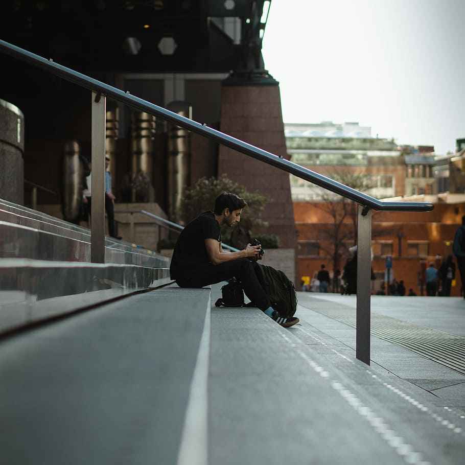 man sitting on concrete stair near road during daytime, man sitting on stair HD wallpaper