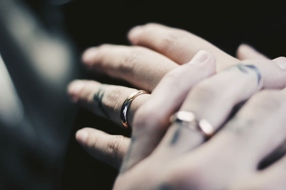 person showing two gold-colored rings, two person with wedding rings HD wallpaper