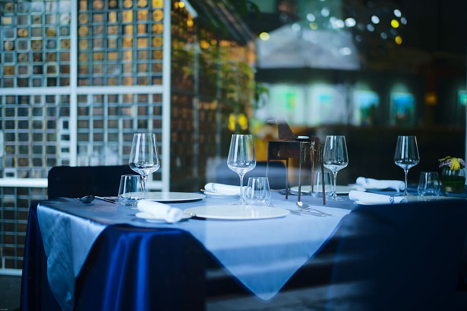 shallow focus photography of wine glasses on blue table cloth covered table, clear wine glasses on table HD wallpaper