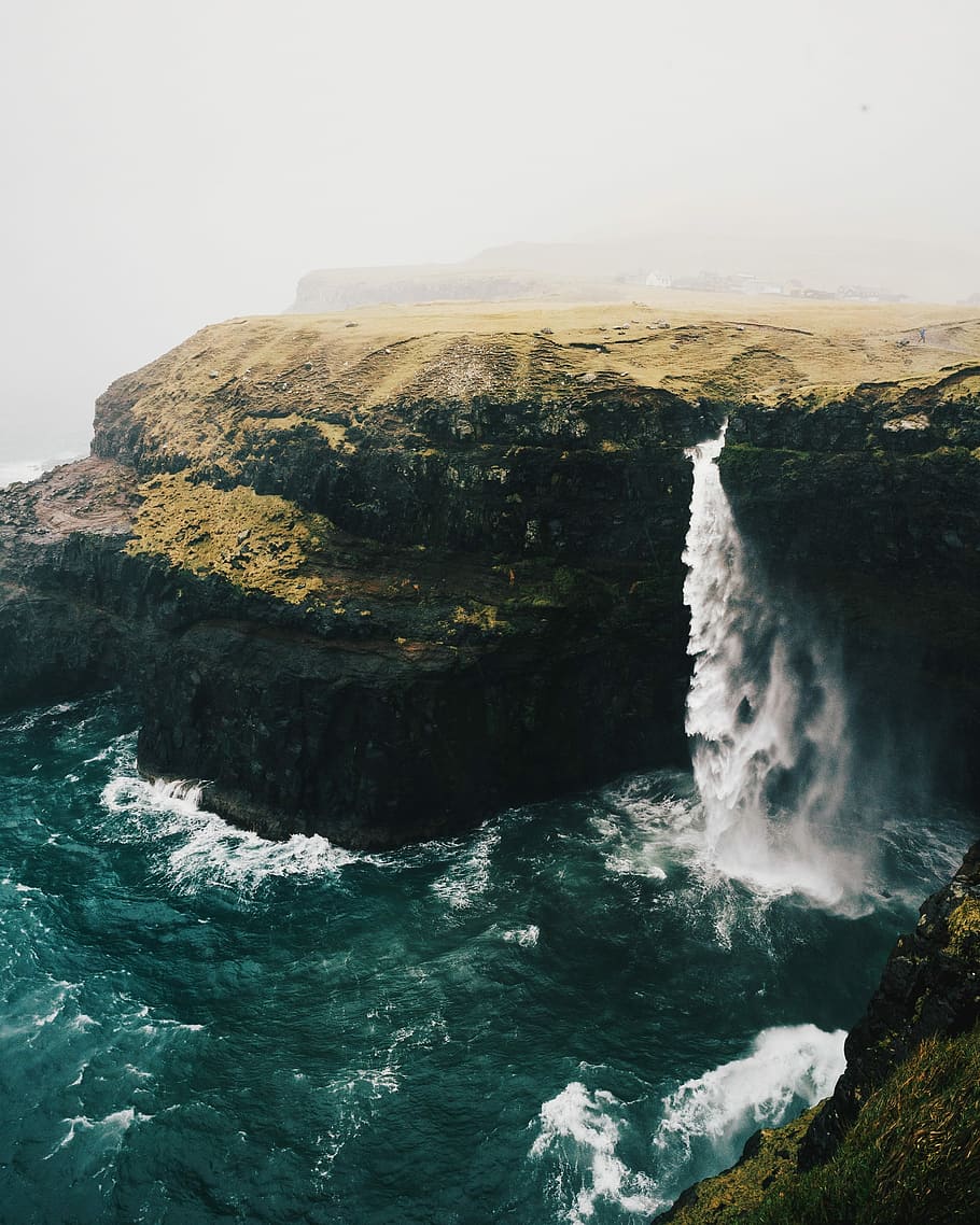 brown and black rock formation near sea during daytime, photo of waterfalls and brown rocks, HD wallpaper