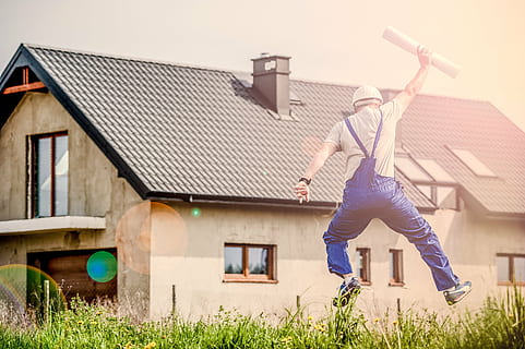 man wearing blue dungaree pants across brown house, building HD wallpaper