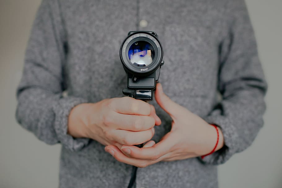 person holding DSLR camera, man holding black video camera, lens HD wallpaper