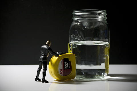 Luke Skywalker action figure placed next to 12-feet yellow ACE steel tape and clear liquid half-filled glass jar HD wallpaper