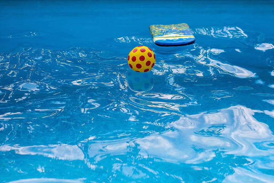 yellow and red soccerball on body of water, pool, beach, summer