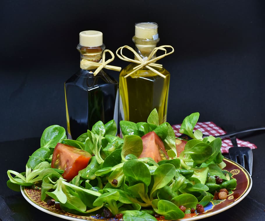 vegetable salad with olive oil bottles, lamb's lettuce, arugula