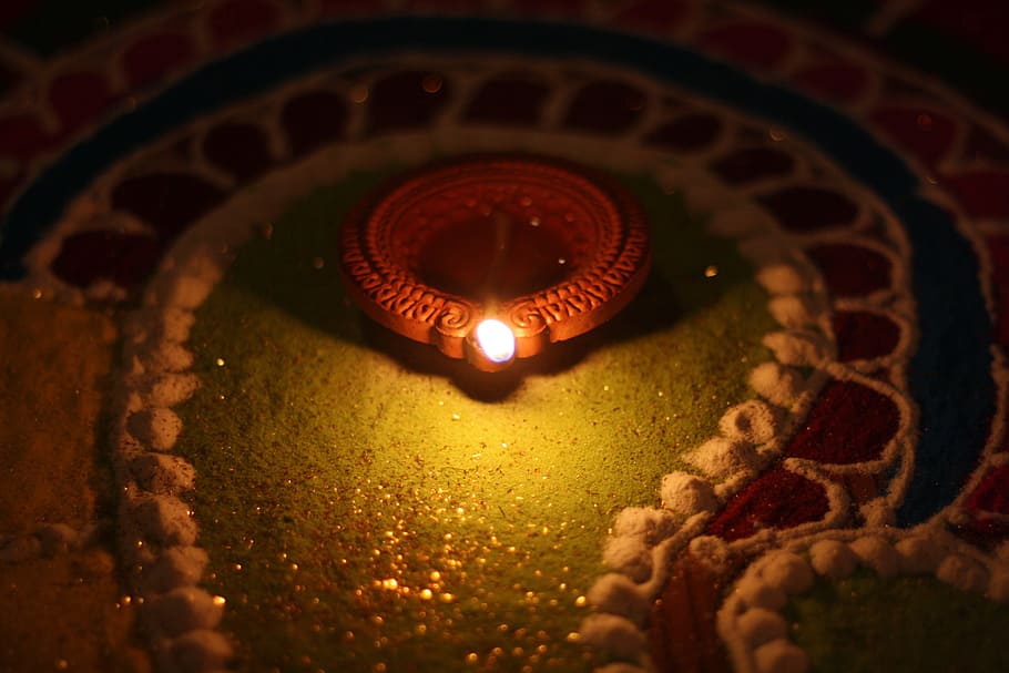 red lighted candle in dimmed room, diwali festival, diwali lamp