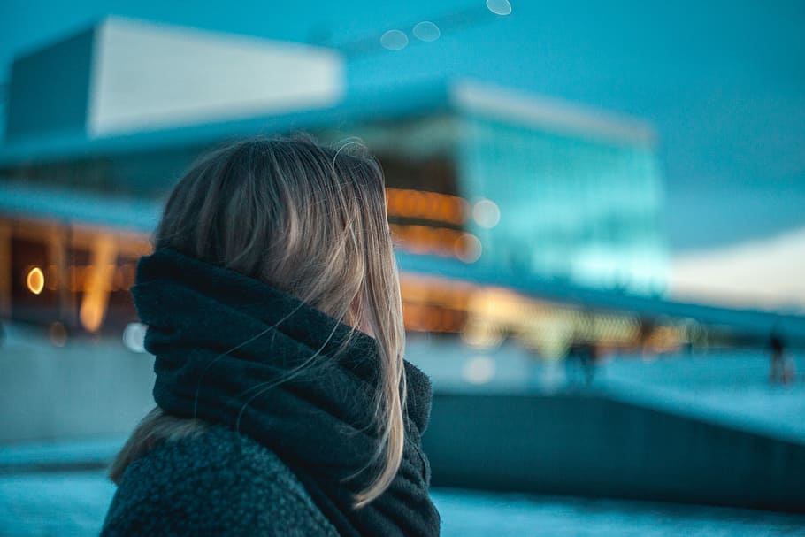 woman standing near building under dark cloudy sky, selective focus photography of woman standing near building HD wallpaper