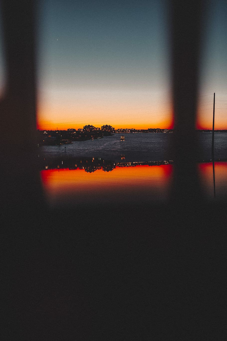 photo of cityscape during twilight hour, silhouette building reflecting on body of water HD wallpaper